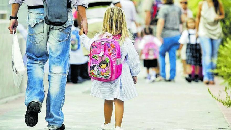 Un padre lleva a su niña de la mano hasta la entrada del colegio. | | E.D.