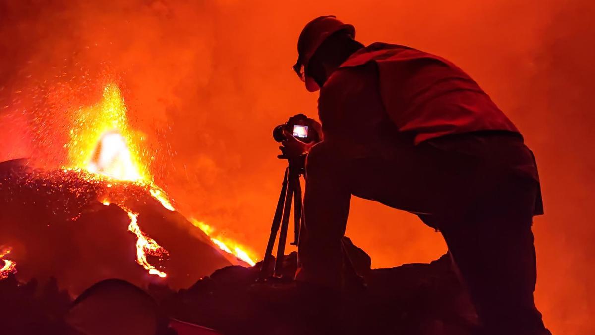 Un investigador fotografía la lava expulsada por el volcán Tajogaite