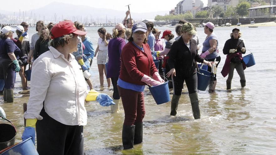 María Juncal (en el centro, con gorra azul), ayer realizando labores como mariscadora en Moaña. // Santos Á.