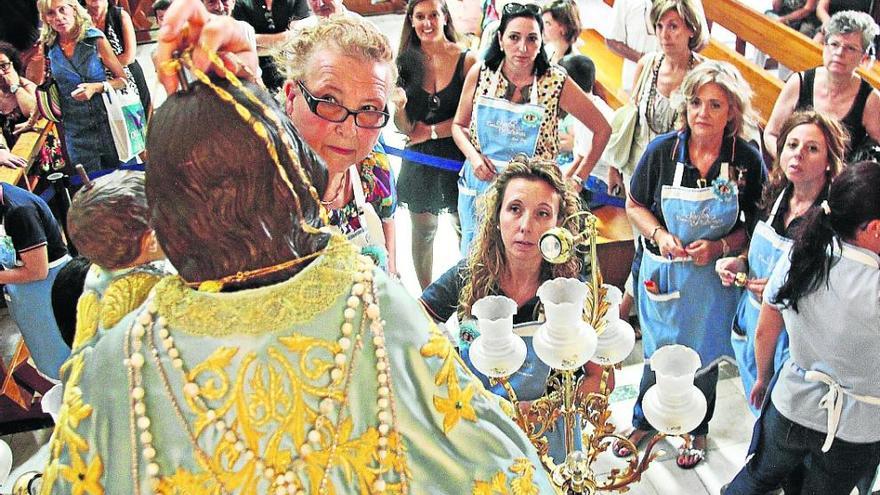 Como cada 6 de septiembre, la comisión de Las Camareras se encargaron ayer de preparar tanto a la Virgen de la Salud como al Cristo del Buen Suceso para las Fiestas Mayores de Elda. Desde hace unos años, las puertas de la parroquia de Santa Ana, donde se lleva a cabo este acto, permanecen abiertas para que los ciudadanos puedan presenciar cómo se engalana a la Virgen. Este año la imagen lucirá el mantón del IV Centenario de los Santos Patronos.