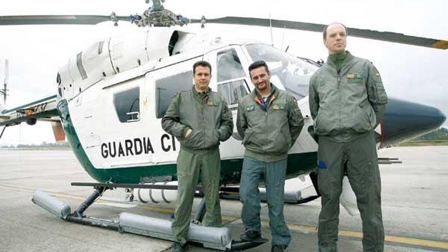 El sargento Lagartera, flanqueado por dos pilotos, frente al helicóptero en Peinador.