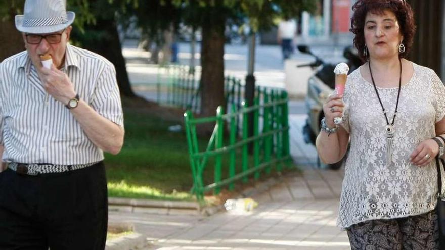 Un hombre y una mujer se refrescan, ayer, con un helado.