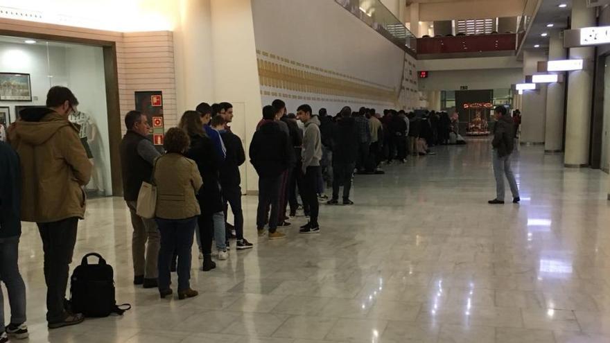 Aficionados, haciendo cola en el centro comercial Modoo