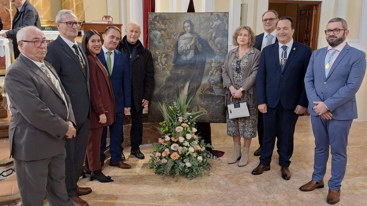 Familiares de Amparo Gomis y autoridades locales, junto al cuadro restaurado.