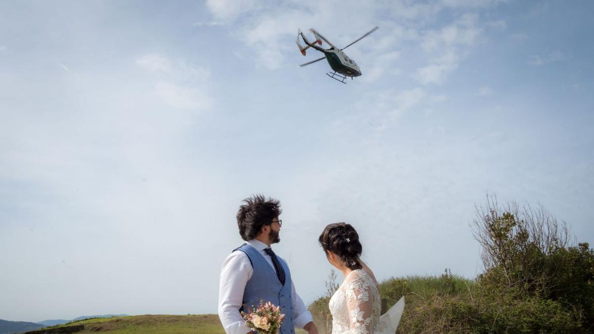 La pareja de novios se da la vuelta para ver el helicóptero próximo a aterrizar.