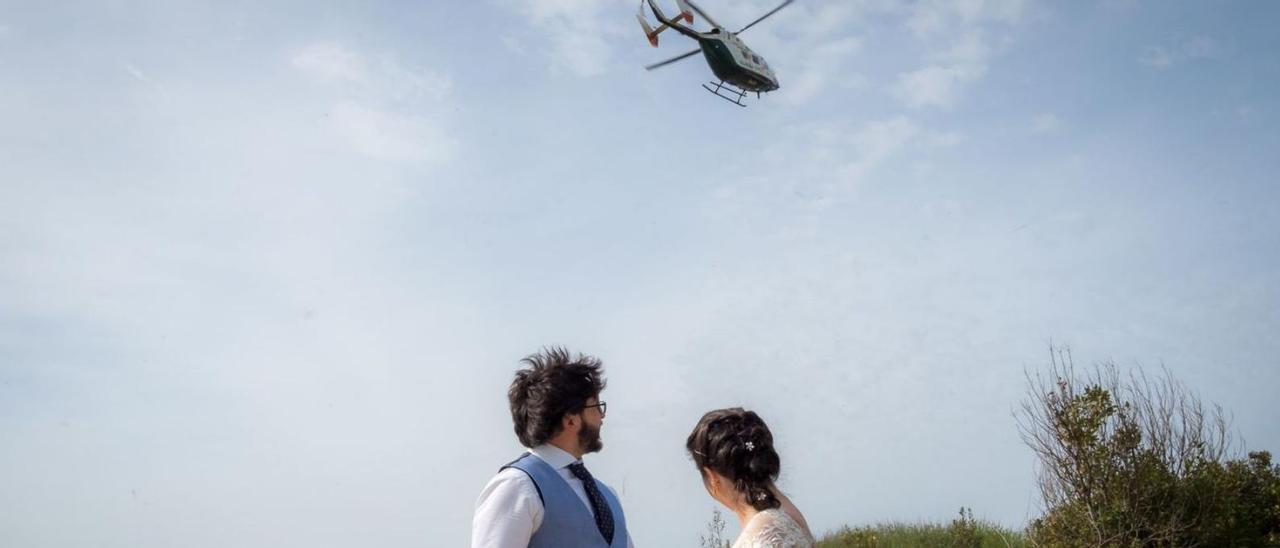La pareja de novios se da la vuelta para ver el helicóptero próximo a aterrizar.   |