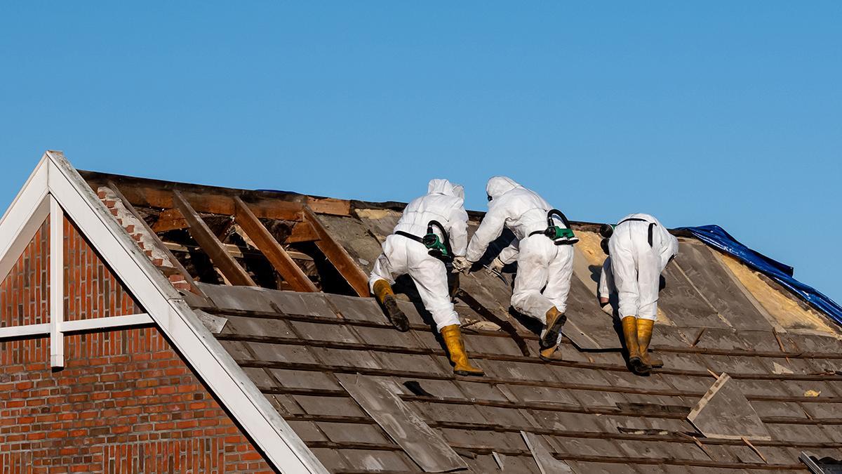 Uns operaris retiren una coberta d'amiant