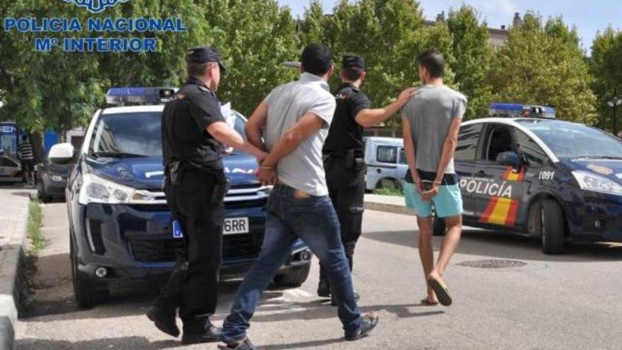 Los dos arrestados, de nacionalidad marroquí, son conducidos por dos agentes.