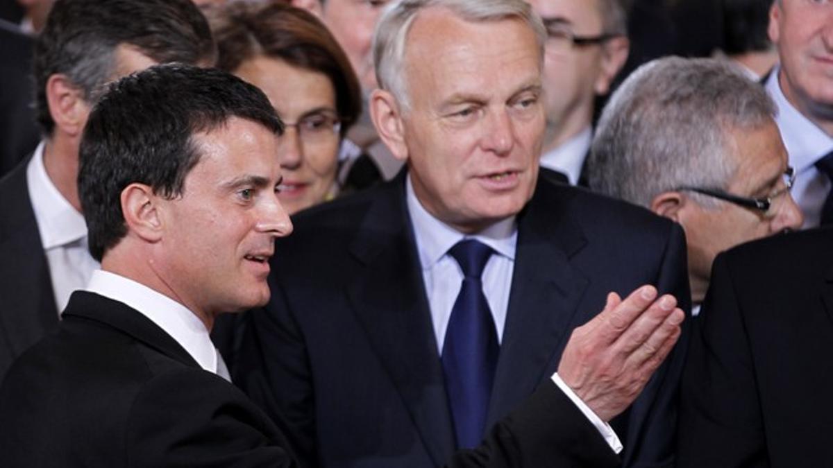 Manuel Valls habla con el dirigente socialista Jean-Marc Ayrault, durante el acto de investidura de François Hollande.
