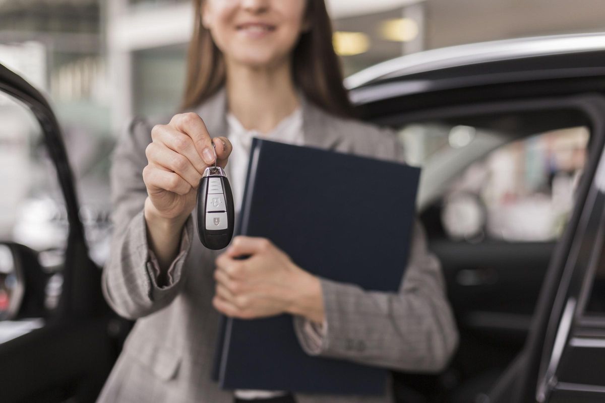 Mujer sosteniendo una carpeta y las llaves de un vehículo