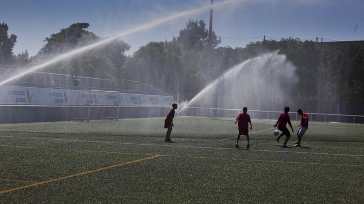 L’equip infantil del CF Barceloneta s’entrena i es remulla al mateix temps.