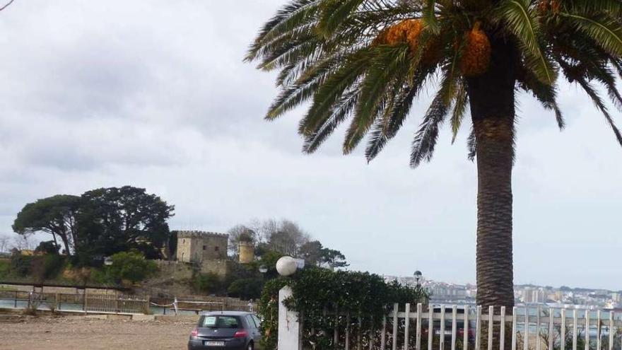 Parcela del Maxi, usada como &#039;parking&#039; en verano, donde se prevé el hotel de cinco estrellas, y el castillo al fondo. i. r.