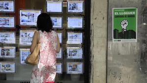 Cartel de la manifestación junto a una inmobiliaria, en la calle de Sants.