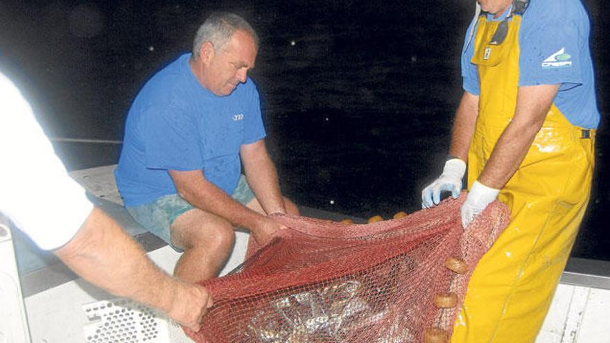 Miembros de la tripulación del Petit Fuat izando un ´vol´ de llampuga en el que se aprecia una gran cantidad de pescado.