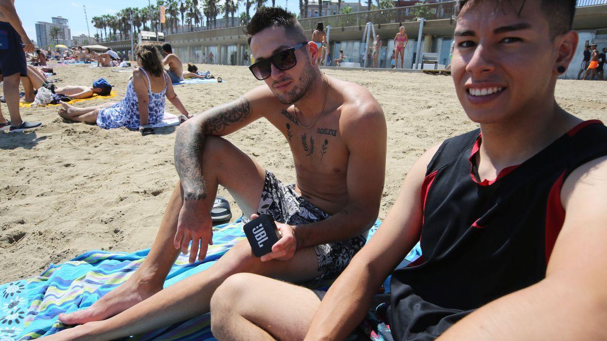 Dos jóvenes escuchan música en la playa con un altavoz inalámbrico, esta semana en Barcelona.