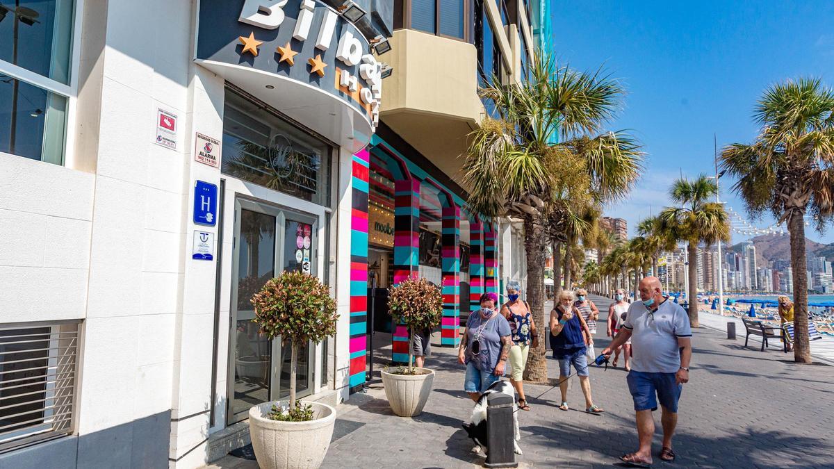 Turistas pasan por un hotel en el paseo de la playa de Levante de Benidorm en una imagen de archivo