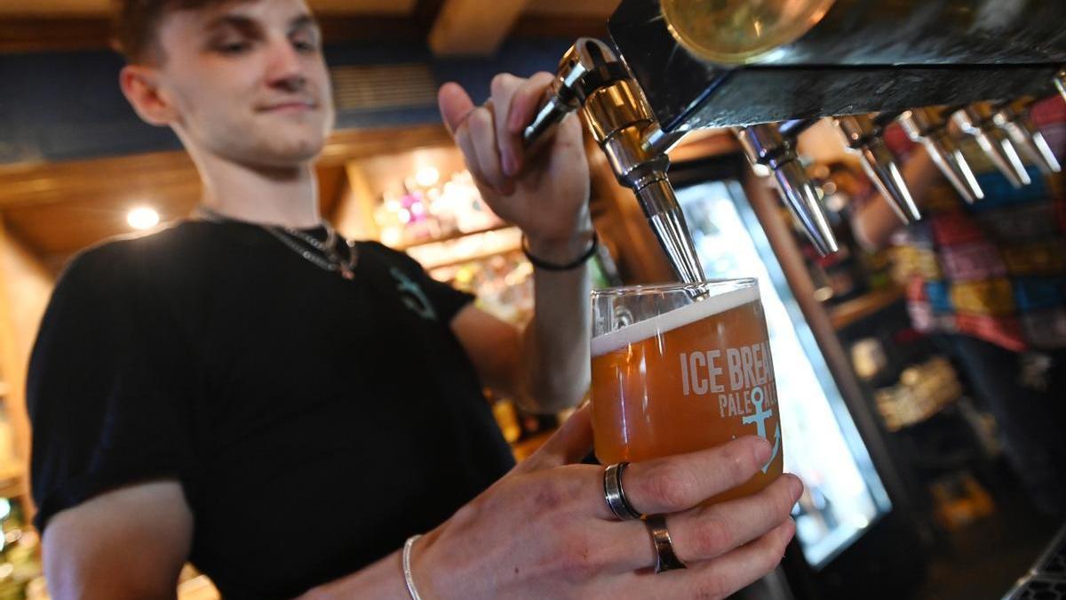 Un camarero sirve una cerveza fría.