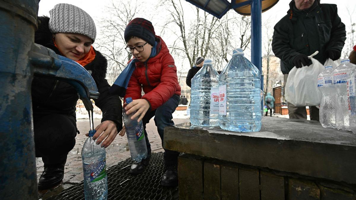 Residentes de Kiev llenan botellas y garrafas de agua, este jueves, tras los ataques que la víspera dejaron sin suministros de luz y agua a la capital.