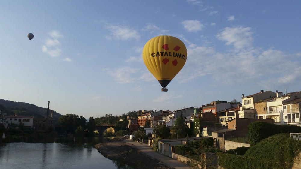 Globus. El groc del globus contrasta amb el cel blau d’aquest dia d’estiu. El nom de Catalunya vola alt per la vila de Sallent.