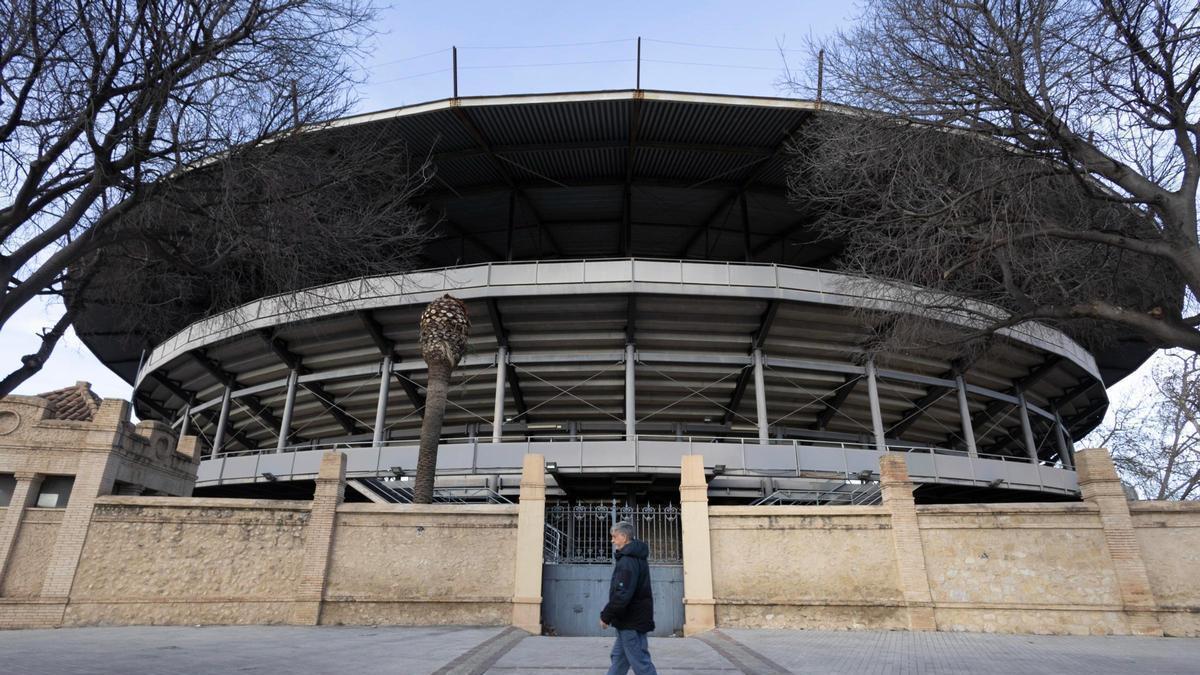 Un hombre pasa por delante de la Plaza de Toros de Xàtiva.