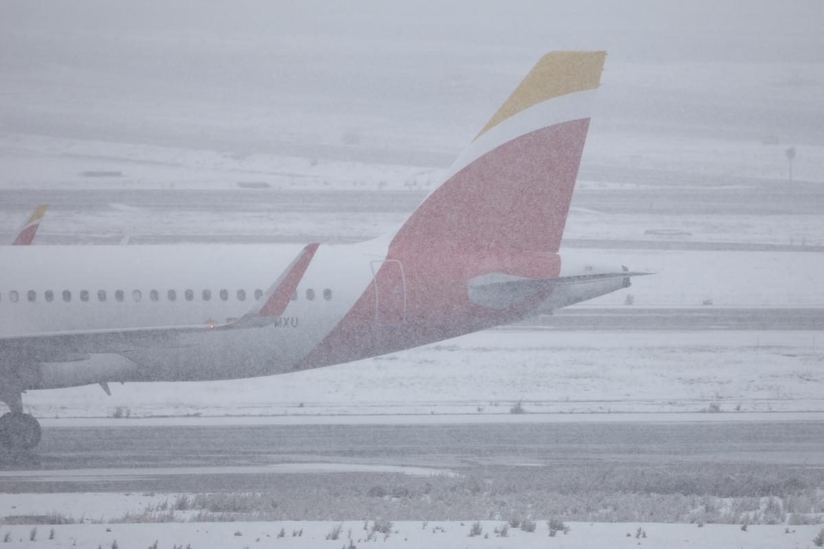 Un avión espera en el aeropuerto de Barajas bajo la nieve.