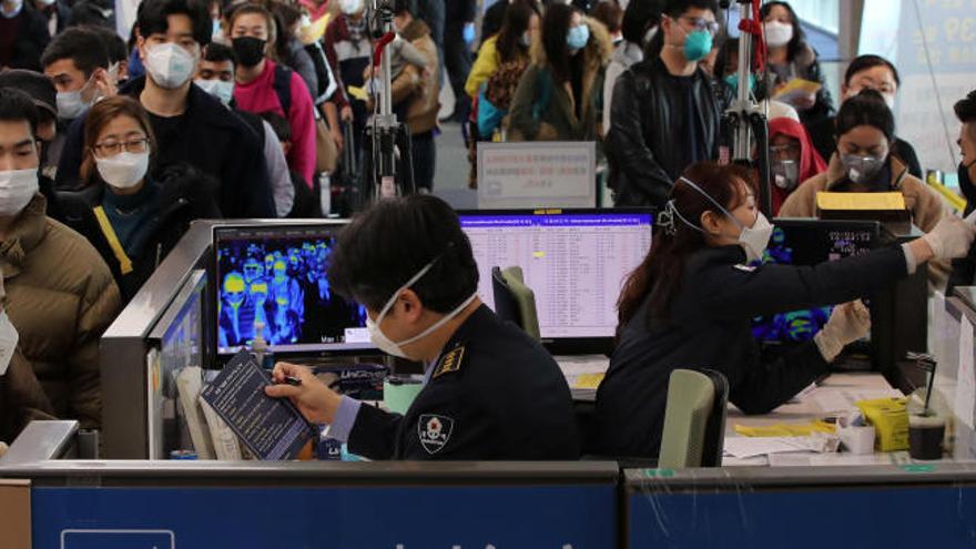 Un aeropuerto chino con usuarios con mascarillas.