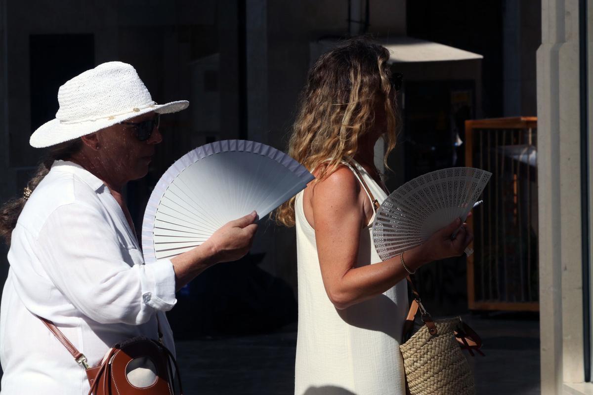 Viandantes soportan las altas temperaturas por las calles de Málaga