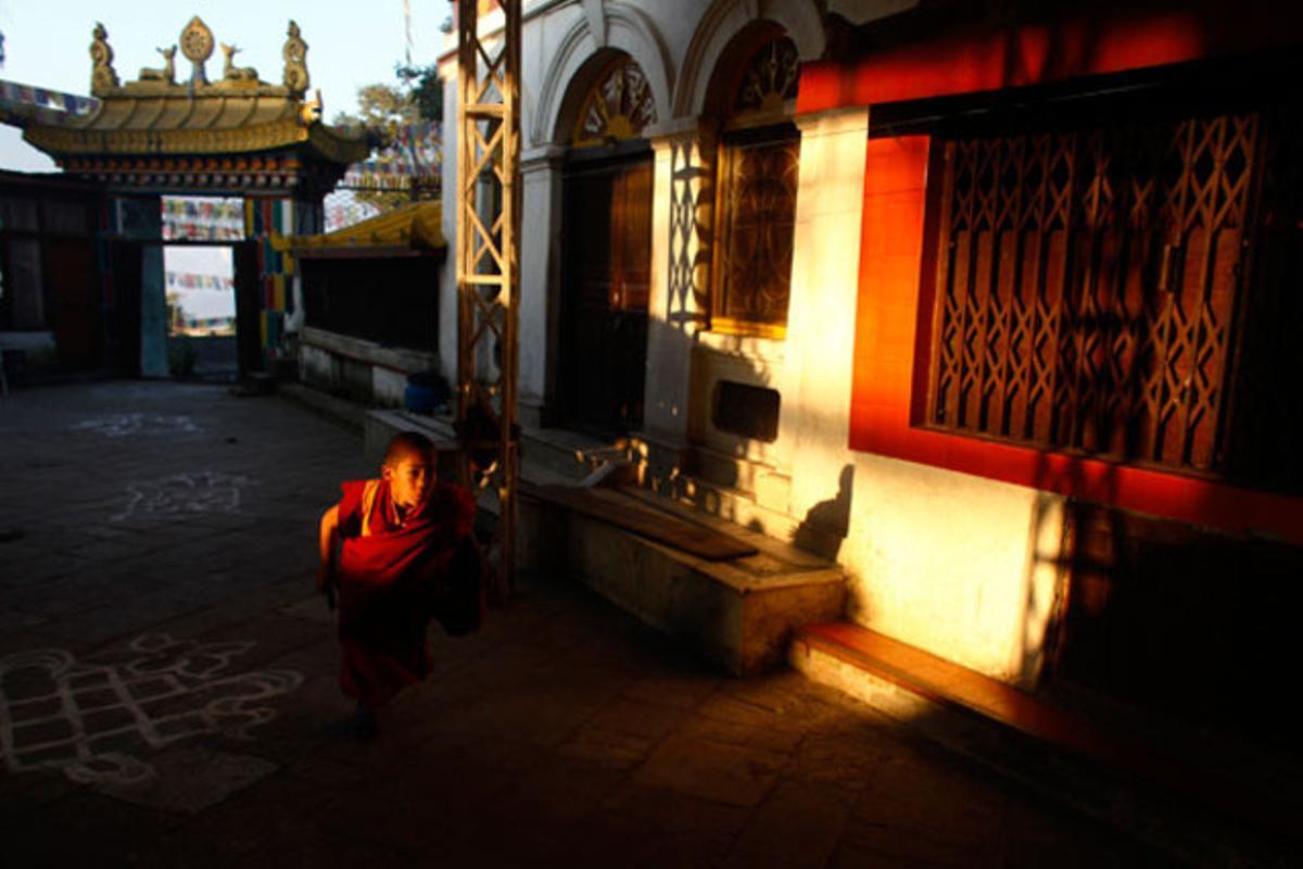 Un jove monjo corre dins del monestir budista de Swayambhu, a Kàtmandu (Nepal).
