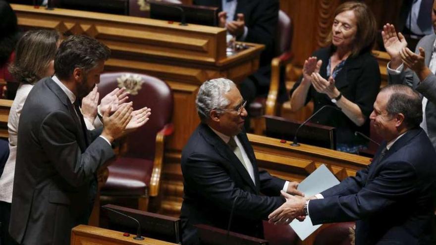 El líder del PS, Antonio Costa, es felicitado tras su discurso contra el programa de gobierno de Passos Coelho.