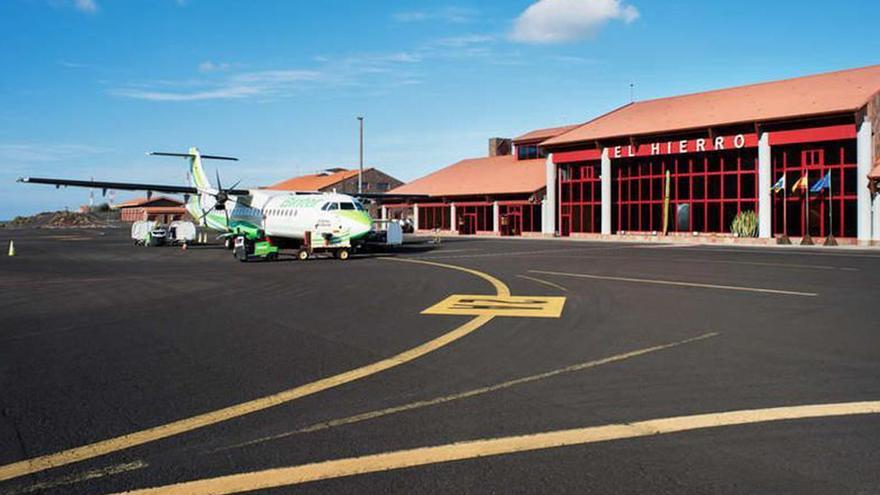 Un avión de la aerolínea Binter es atendido por los operarios en la plataforma de Los Cangrejos.  |