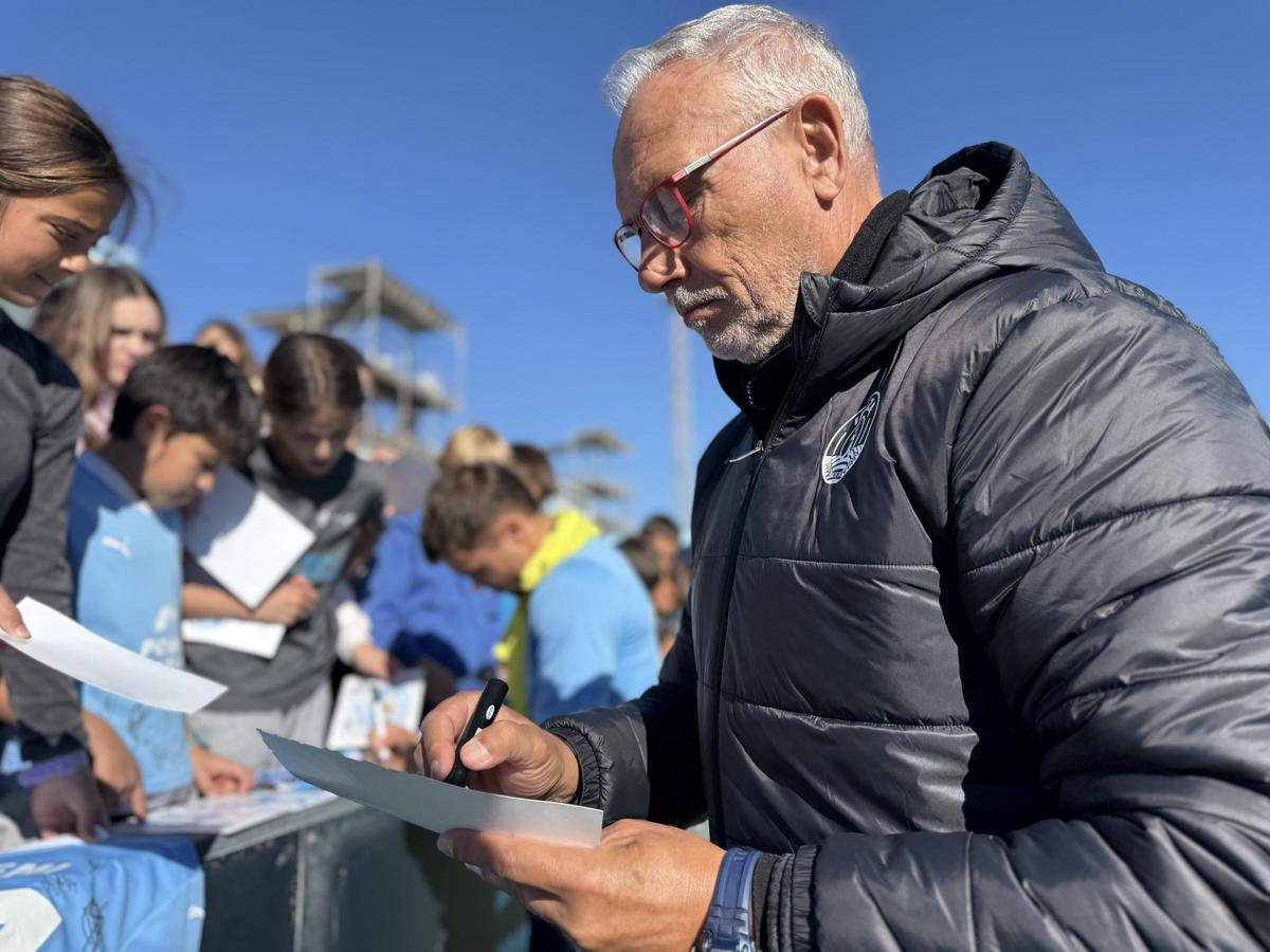 El técnico de la UD Ibiza, Miguel Álvarez, firma autógrafos a los escolares que visitaron el entrenamiento del equipo