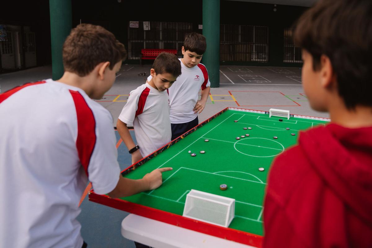 Niños juegan al fútbol chapa en el Colegio Claret de Madrid.