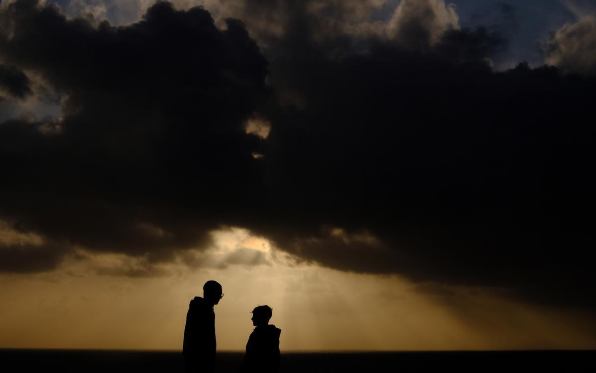 FERROL (A CORUÑA), 08/04/2024.- Curiosos mirando este lunes hacia la puesta de sol en Ferrol, A Coruña, donde las nubes han impedido disfrutar del eclipse parcial de sol. EFE/Kiko Delgado