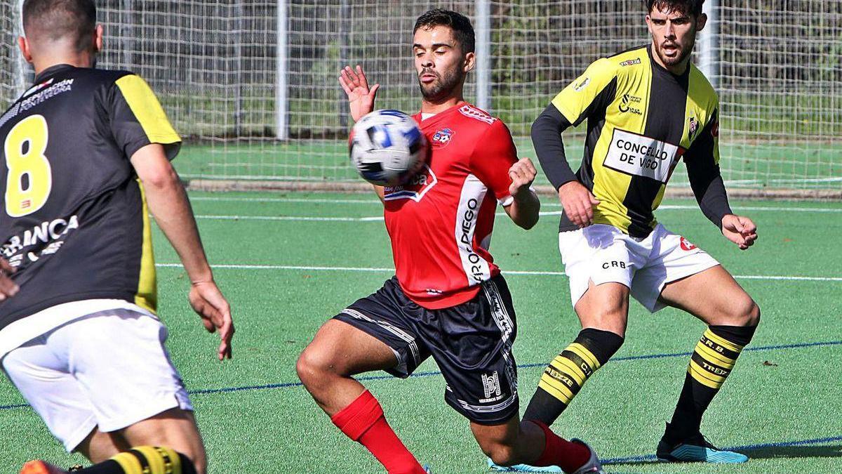 Ube controla el balón entre dos jugadores del Rápido de Bouzas.