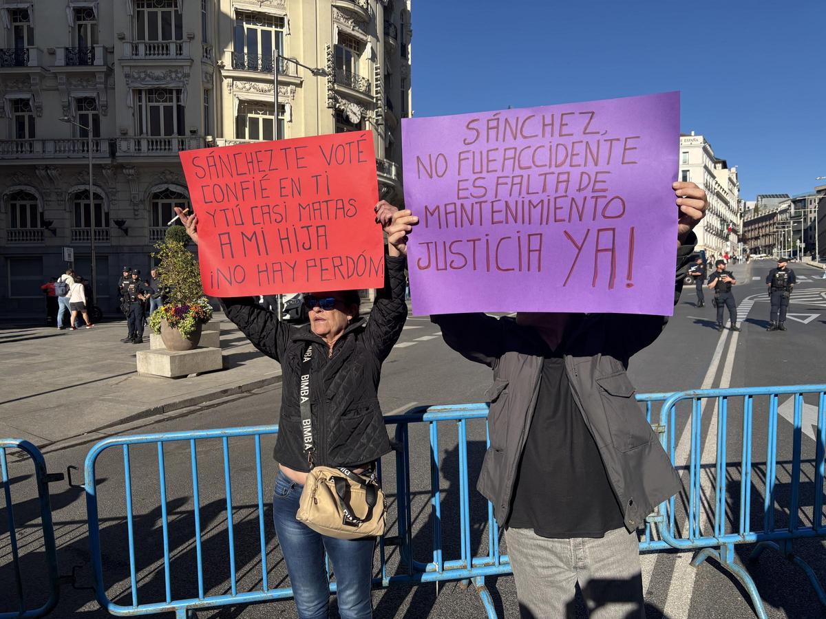 Dos manifestantes exhibiendo pancartas en la concentración