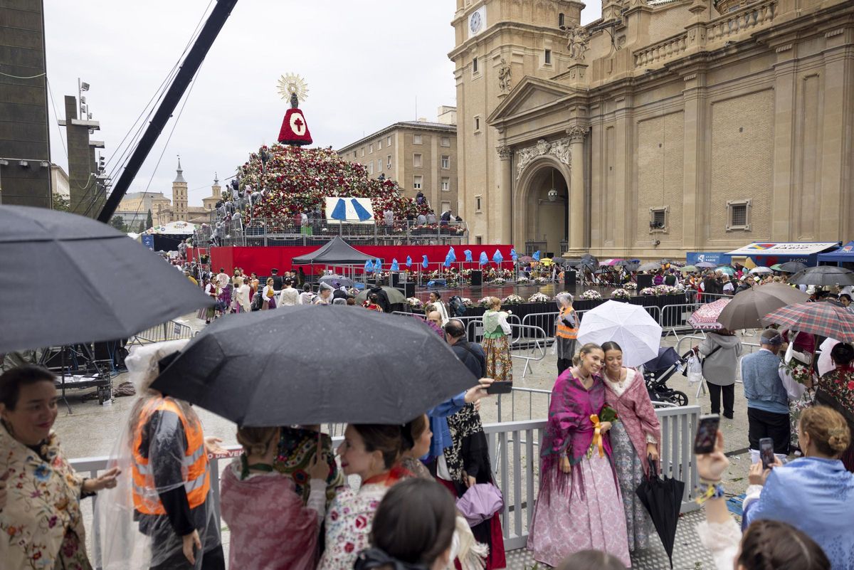 Ciudadanos en la Ofrenda de Flores bajo la lluvia