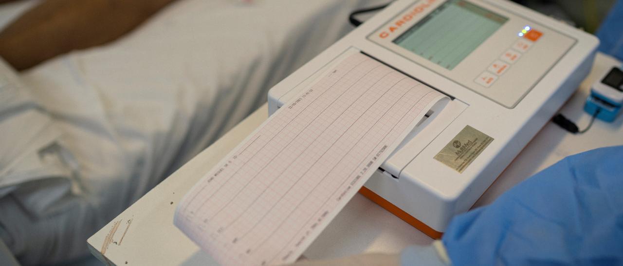 Un sanitario lee el electrocardiograma de un paciente.