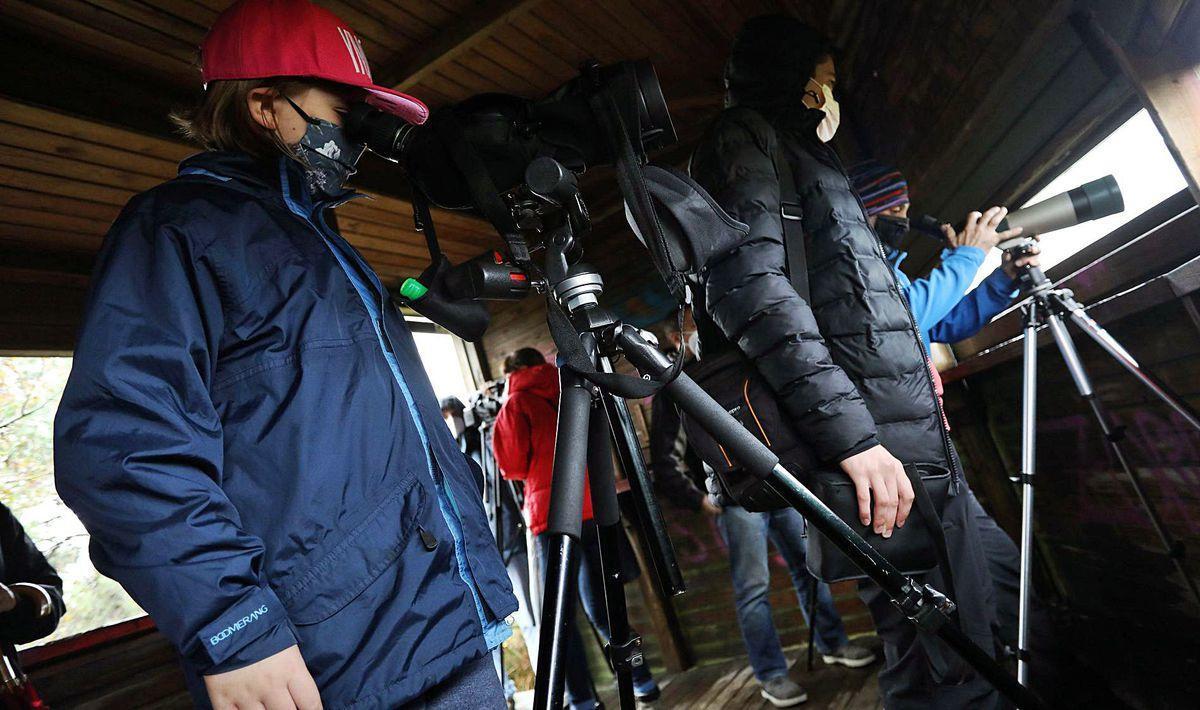 Carolina Tejero observando aves, ayer, en la ensenada de Llodero junto a su hermana Irene e integrantes del grupo ornitológico Mavea.