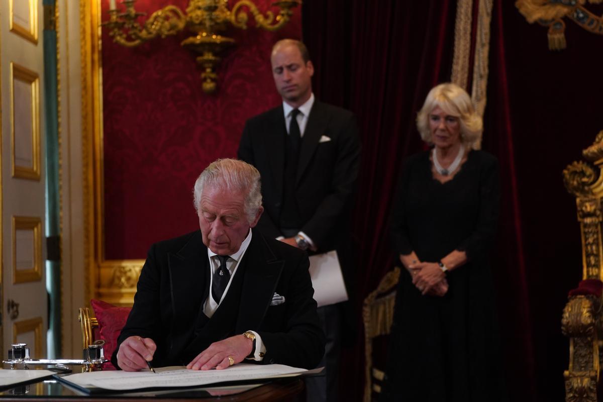 El rey Carlos III firma uno de los documentos durante la ceremonia de su proclamación.