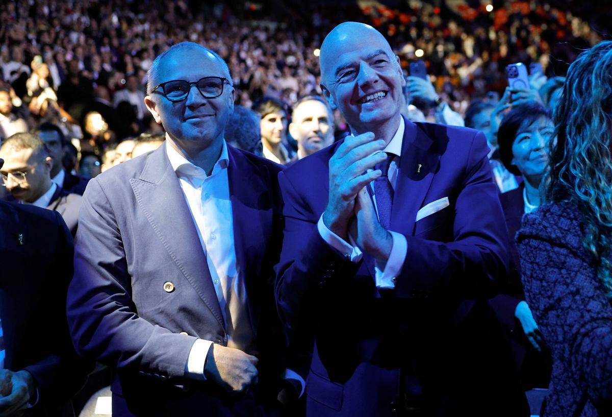 MIAMI, FLORIDA - NOVEMBER 05: CEO of Formula 1 Stefano Domenicali (L) and President of FIFA Gianni Infantino stand as U.S. President Donald Trump speaks during the America Business Forum at the Kaseya Center on November 05, 2025 in Miami, Florida. The forum brings together global leaders, cultural figures and innovators from various sectors for discussions on business, technology and social development. Kevin Dietsch/Getty Images/AFP (Photo by Kevin Dietsch / GETTY IMAGES NORTH AMERICA / Getty Images via AFP)