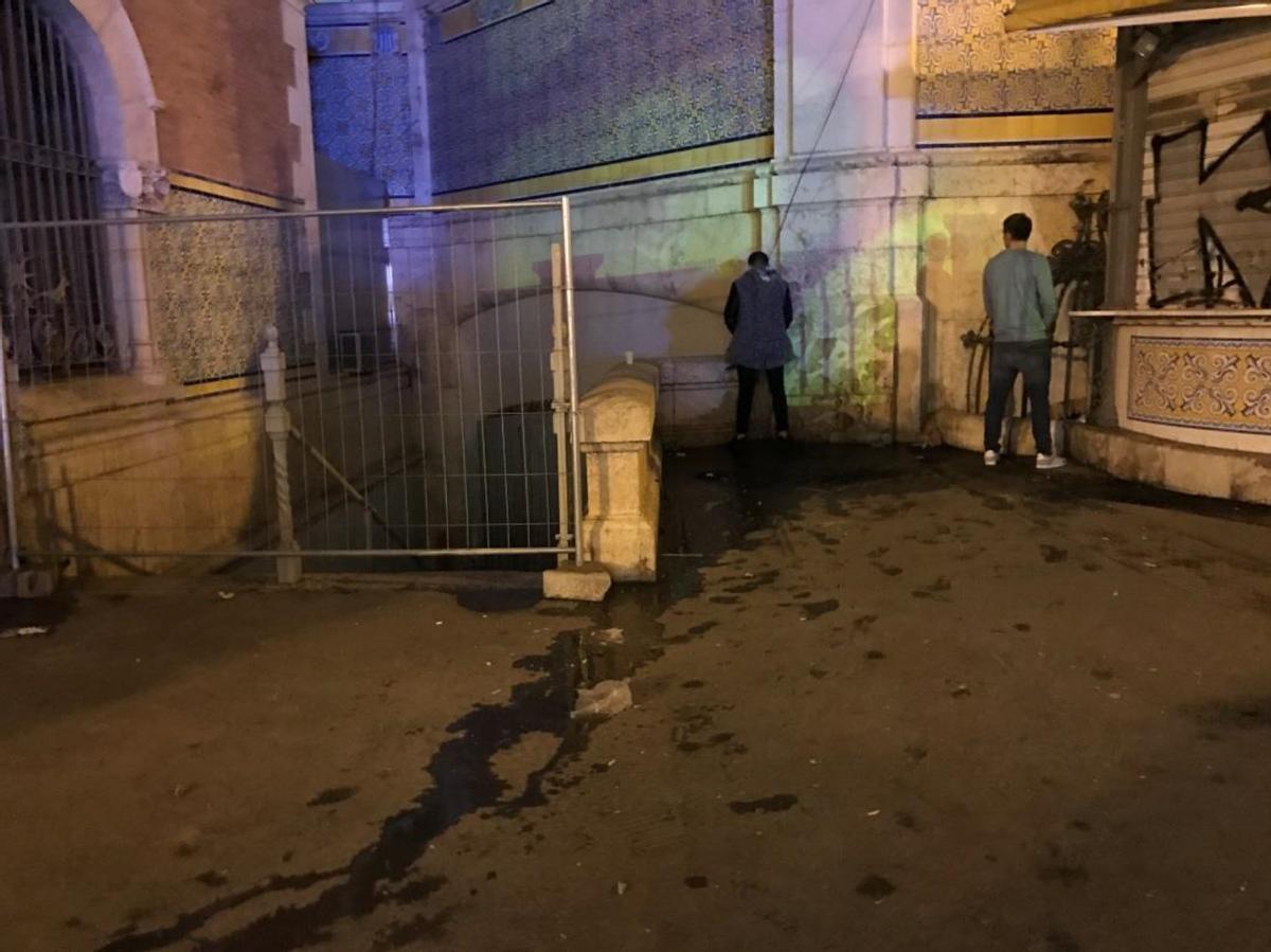 Dos hombres orinan junto al mercado central