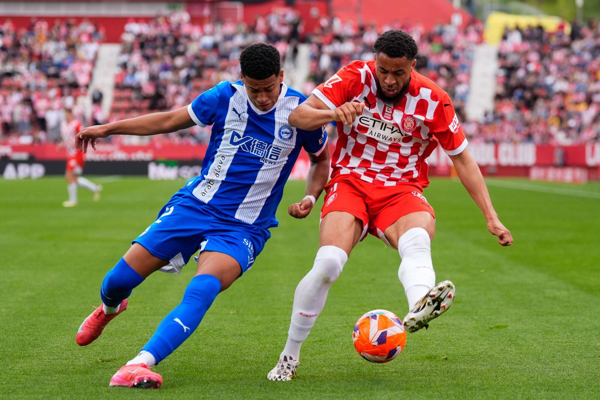 GIRONA, 05/04/2025.- El defensa del Deportivo Alavés Santiago Mouriño (i) y el centrocampista del Girona Arnaut Danjuma, en acción durante el partido de LaLiga entre el Girona y el Deportivo Alavés este sábado en el estadio Montilivi en Girona. EFE/ Siu Wu