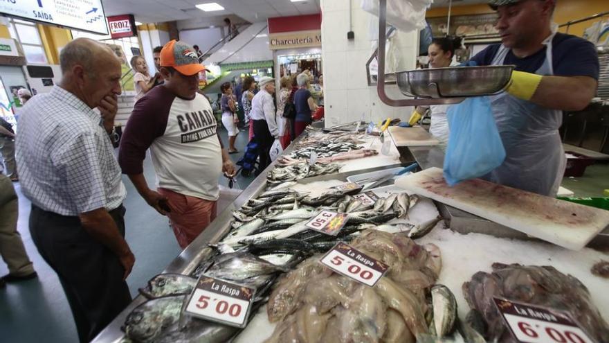 Dos compradores, ayer, en un puesto de venta de sardinas en el mercado de O Calvario. // Adrián Irago