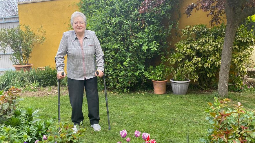 Margarita Martínez, usuaria de CuidándoTe, pasea en el jardín de su casa.