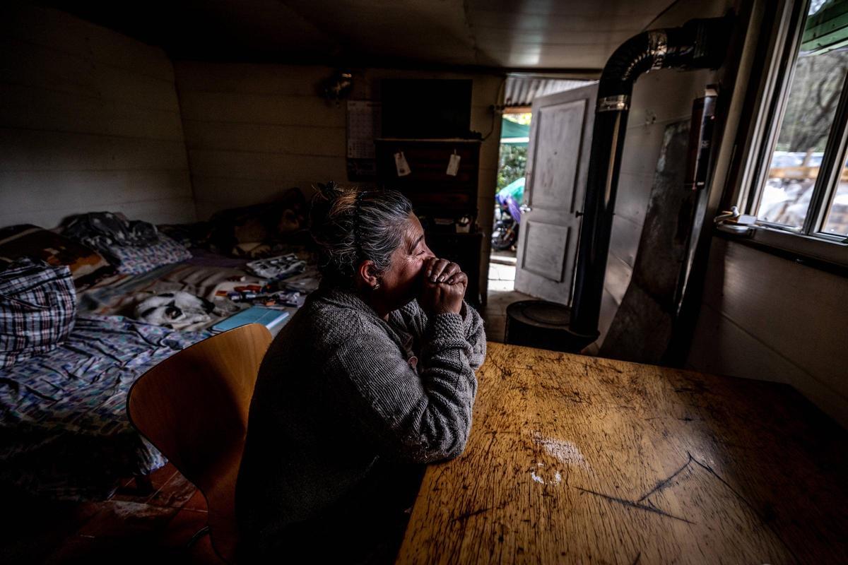 Piedad mira pensativa por la ventana de la chabola donde vive con el resto de su familia.