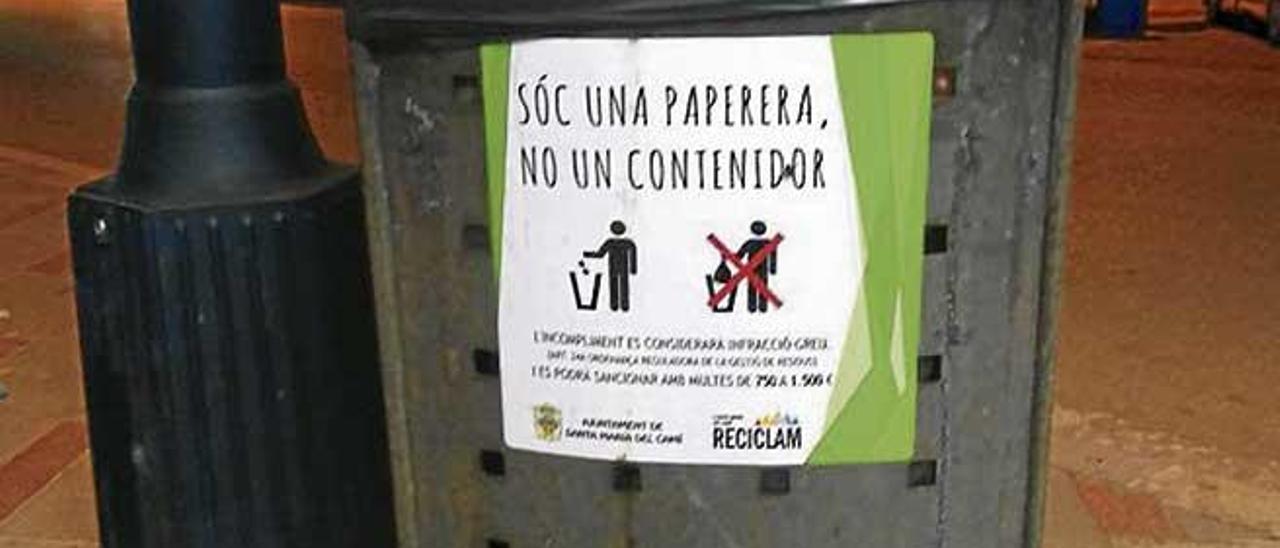 Una de las papeleras con los carteles de advertencia.