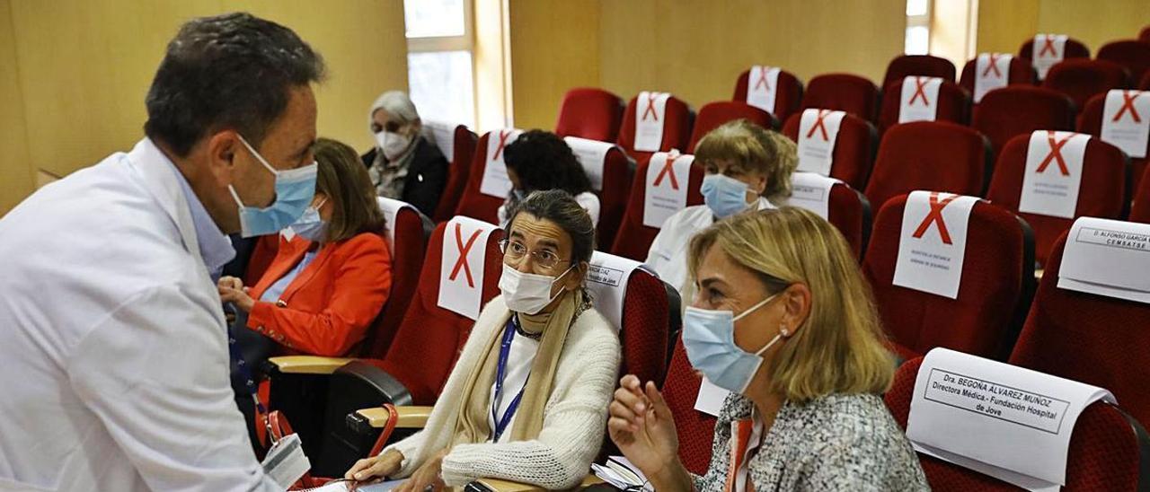 El gerente de Cabueñes, Manuel Bayona, charlando con Begoña Álvarez y Laura Díaz, responsables de Jove, minutos antes del consejo de salud celebrado ayer en el salón de actos del hospital público. | Marcos León