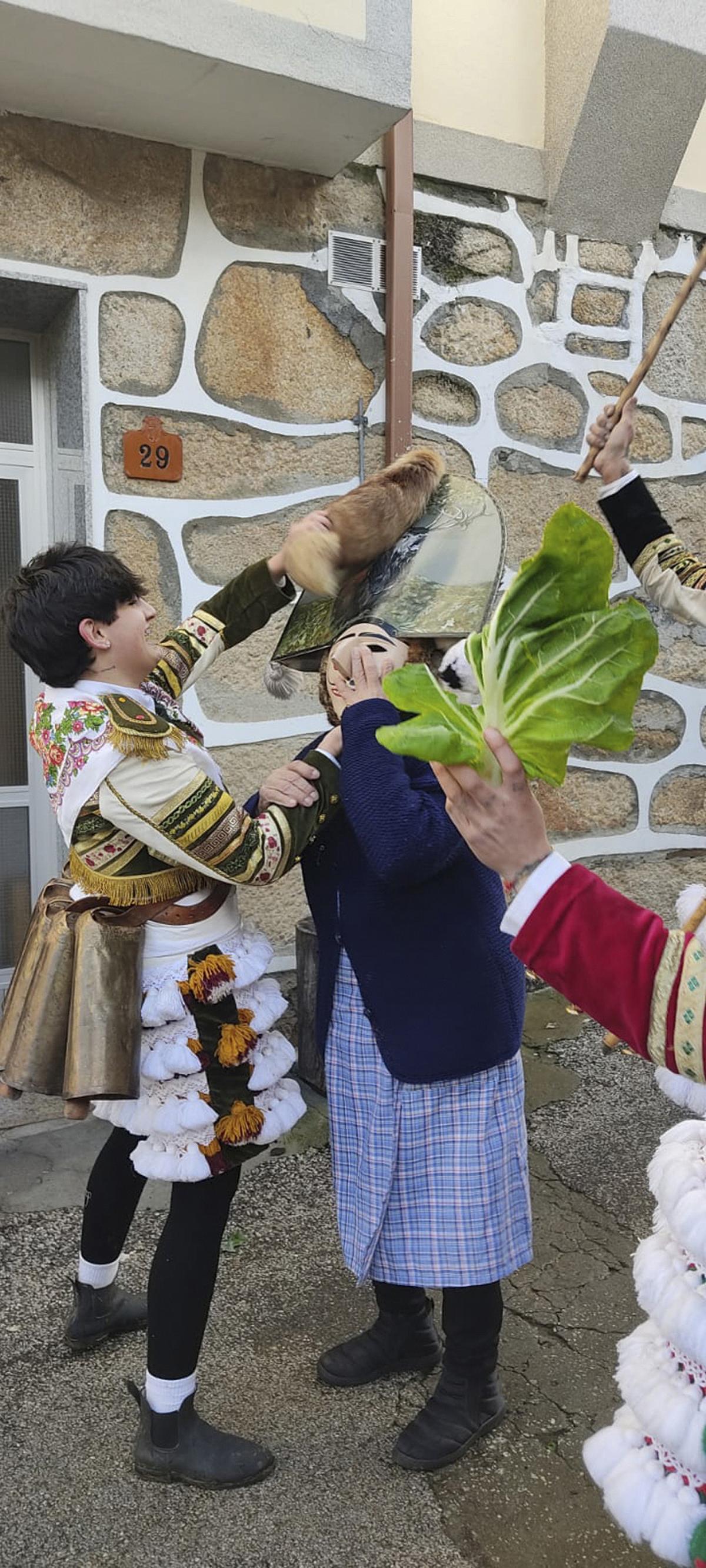 Uno de los felos coloca su máscara a una vecina mayor.