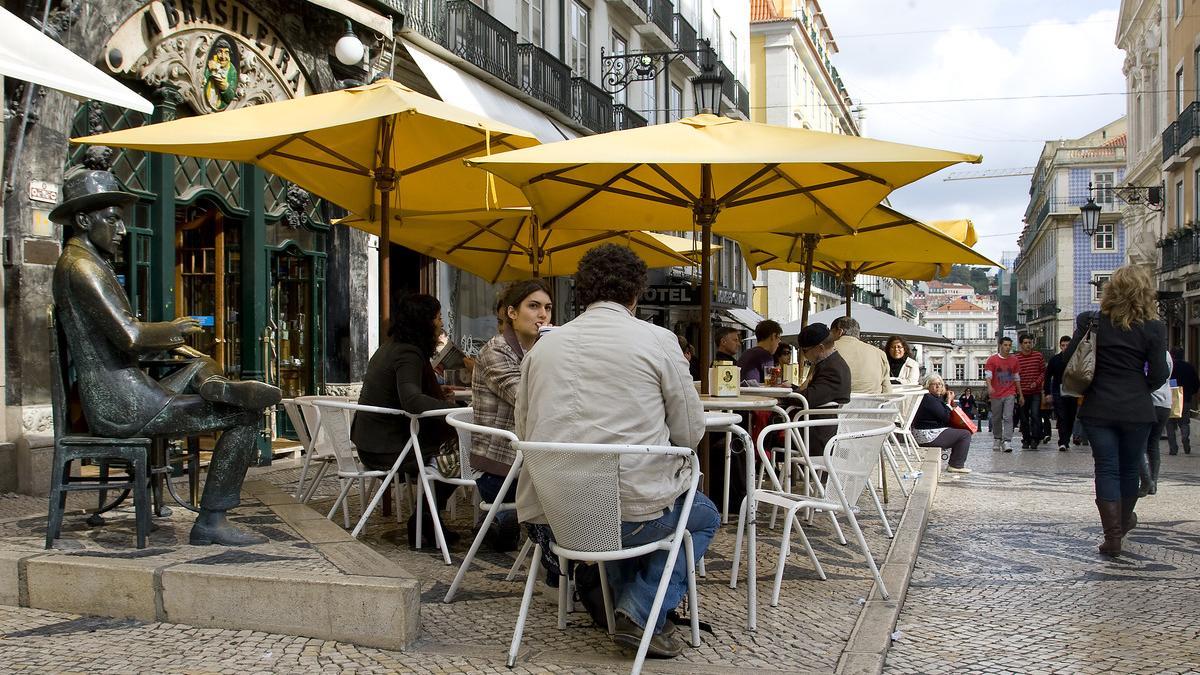 Turistas en Lisboa junto a la estatua de Fernando Pessoa.