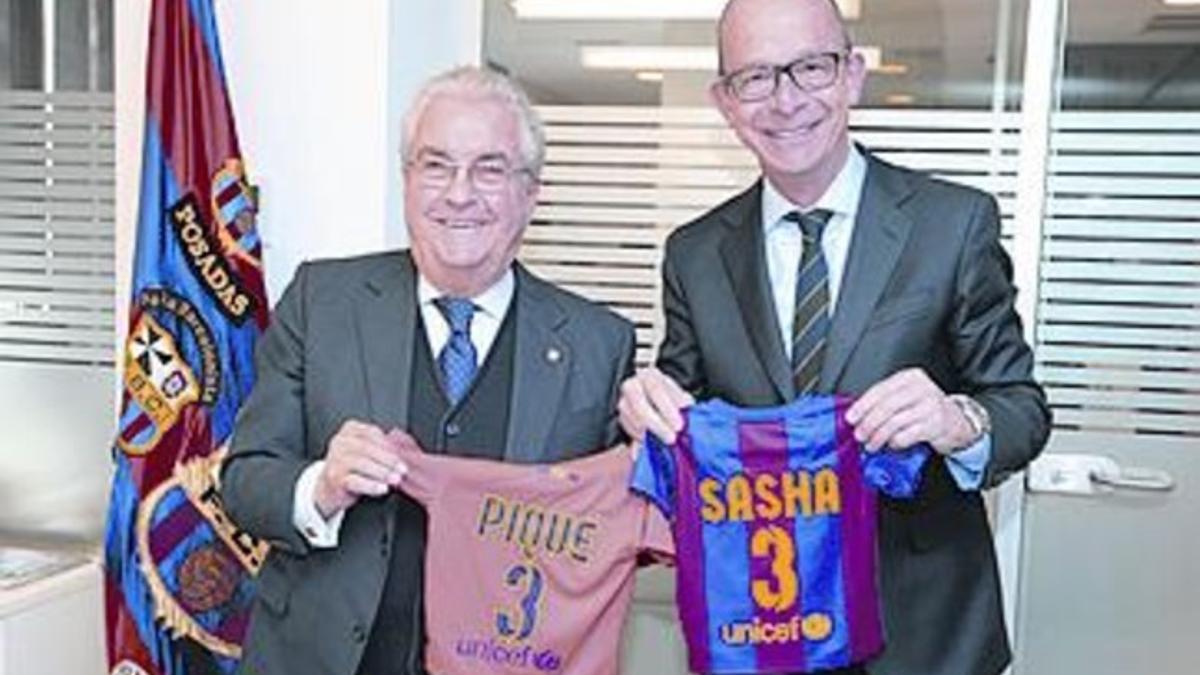 Bernabéu y Jordi Cardoner con la camiseta de Sasha, y el carnet del niño.